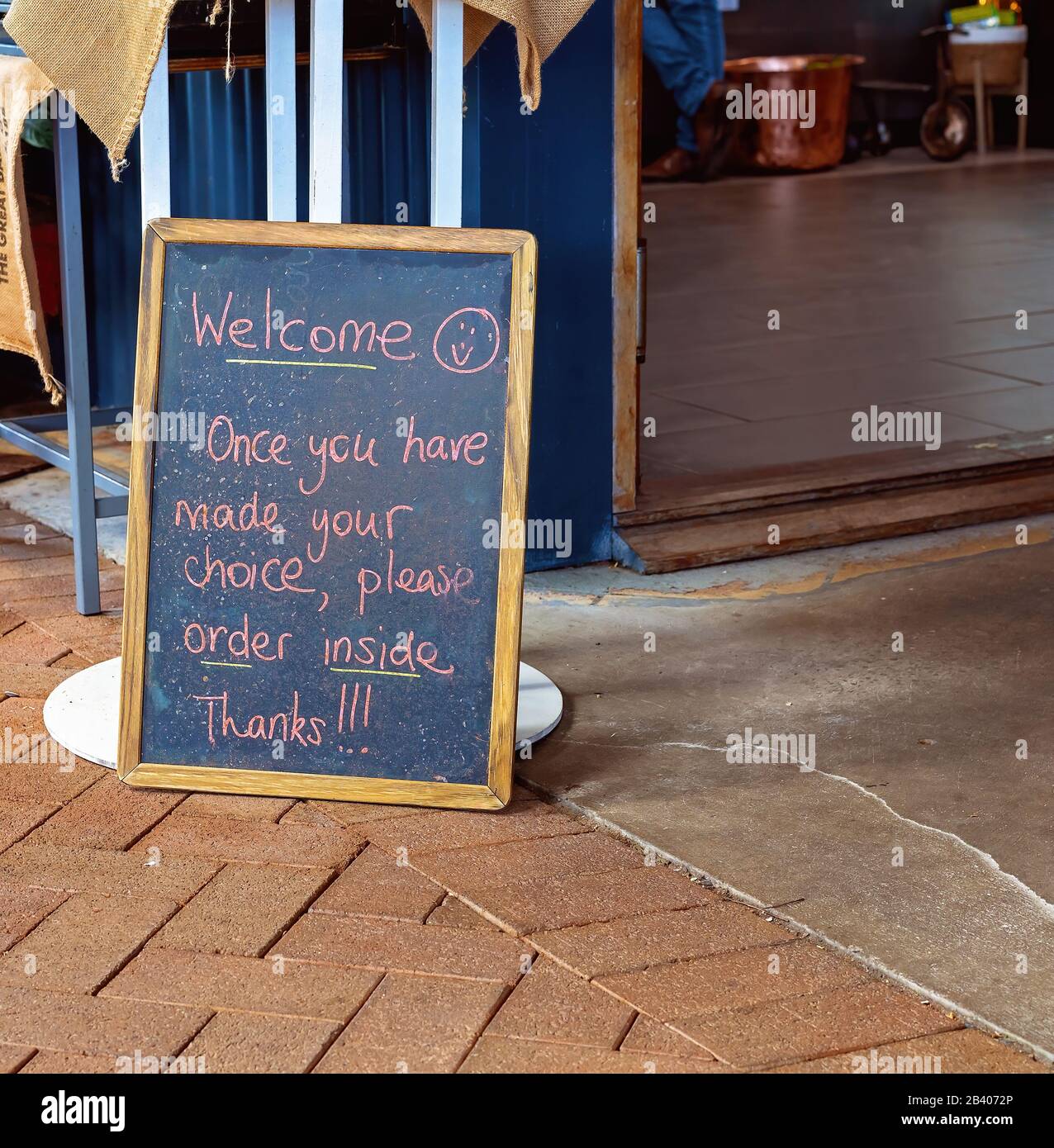 A blackboard sign at a casual outdoor cafe with instructions to order inside Stock Photo