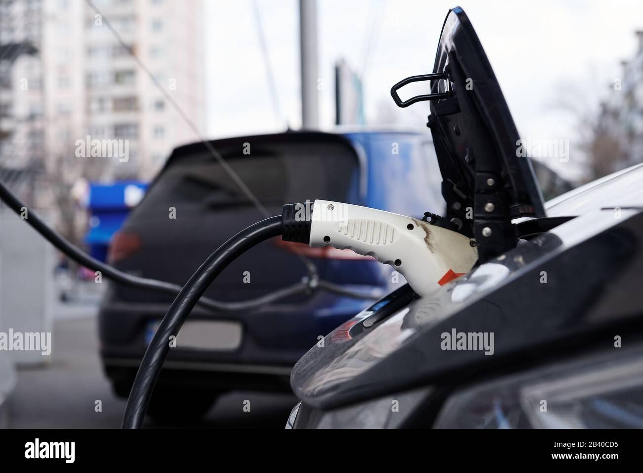 White plastic plugin connector in the electric car. Car while charging battery. Ecological
