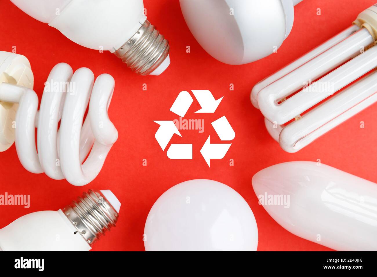 Spent incandescent halogen, cfi fluorescent, led, lumens light and energy saving bulbs tube, red background, Recycling sign. Lamps containing mercury Stock Photo