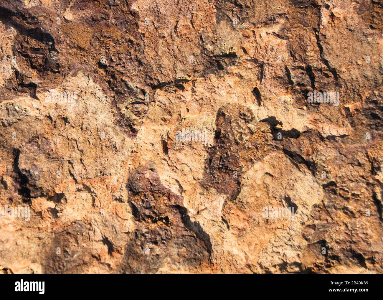A close up view of rough hewn and peeling red brown rock. Stock Photo