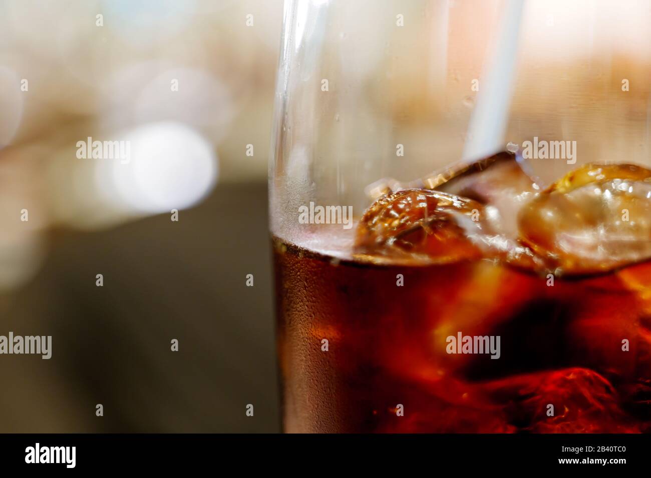 https://c8.alamy.com/comp/2B40TC0/close-up-and-macro-view-of-cola-and-ice-cube-with-steam-on-glass-and-blur-abstract-background-of-bokeh-2B40TC0.jpg