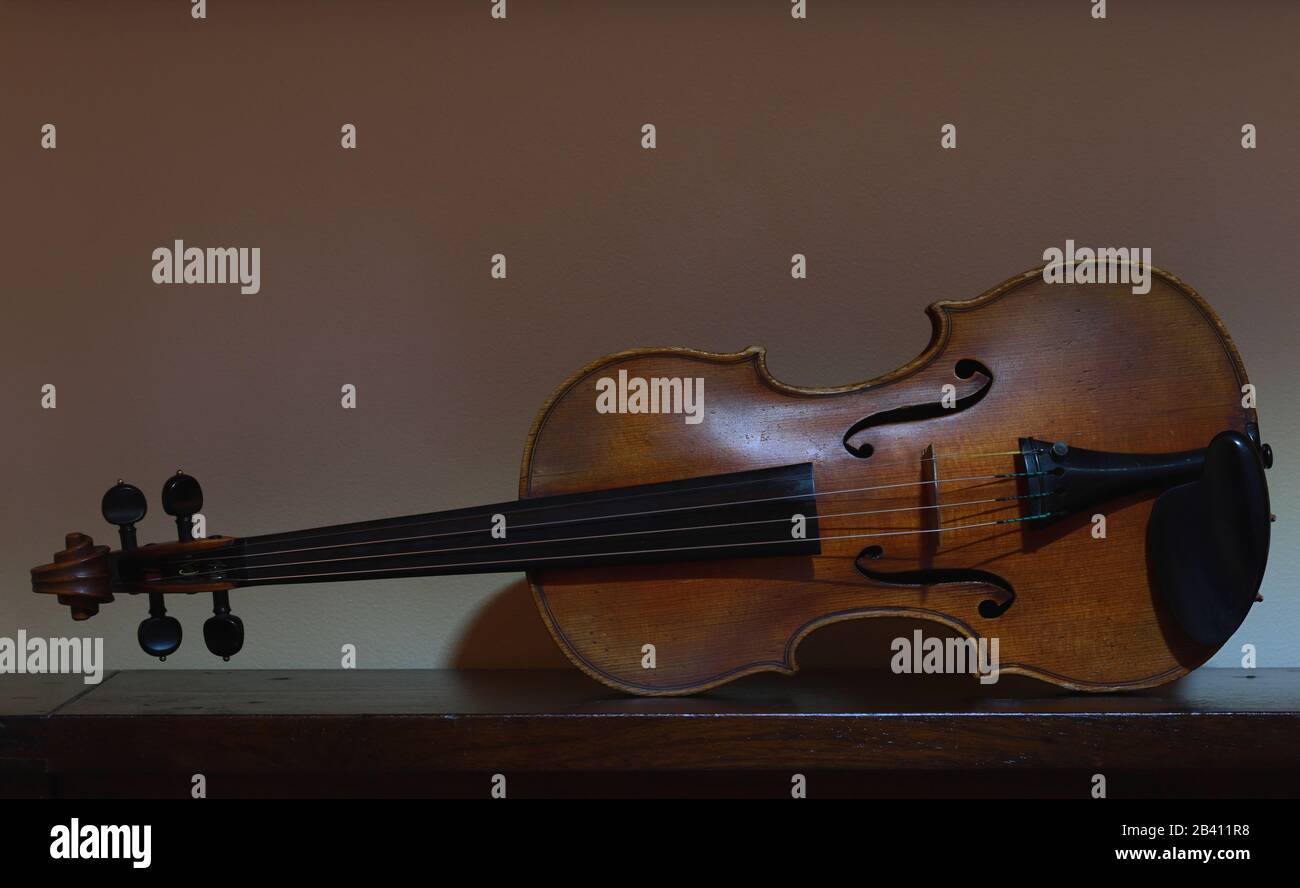 Violin sitting on its side and resting on a table. Stock Photo