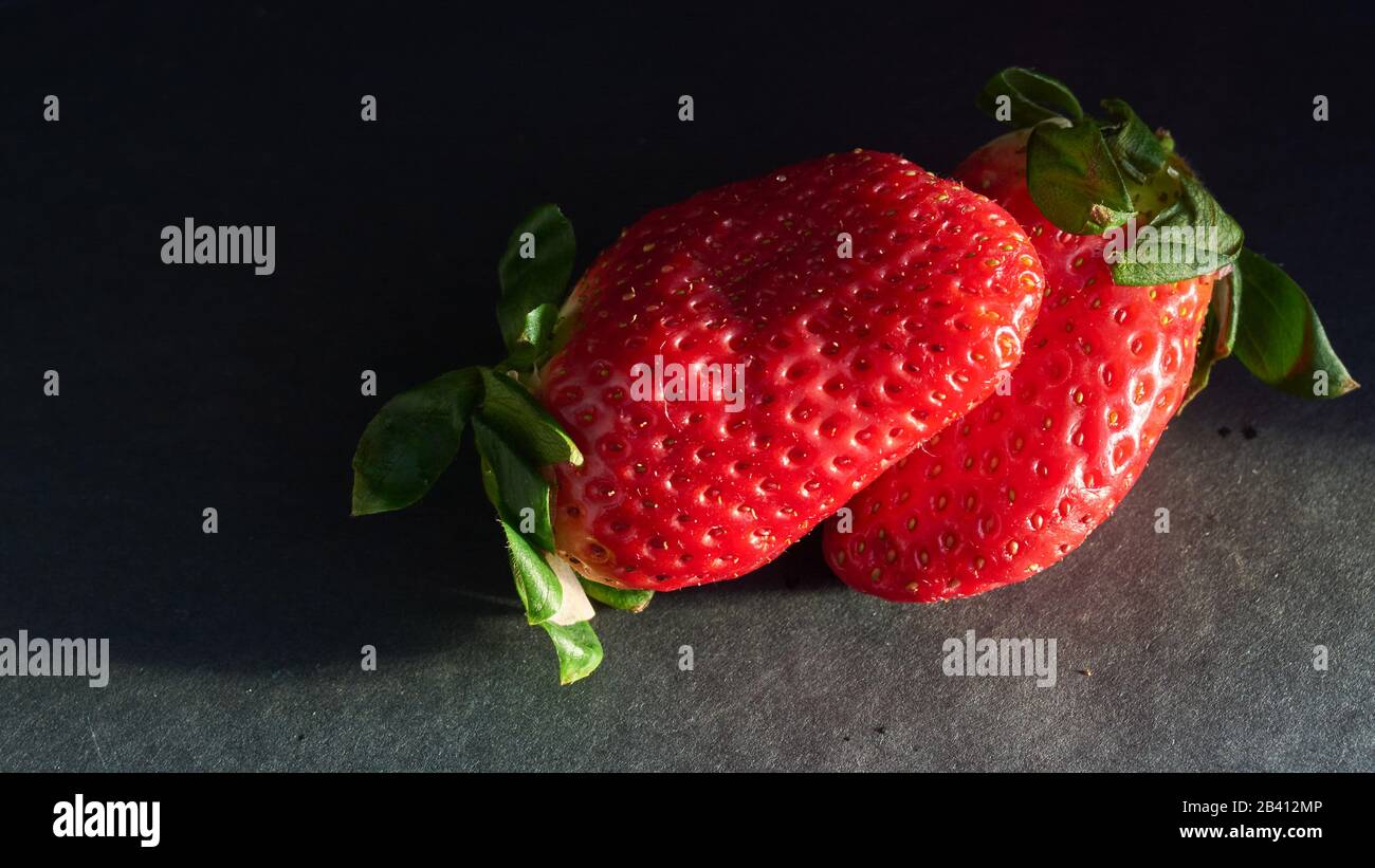 strawberries with natural light and black background Stock Photo - Alamy