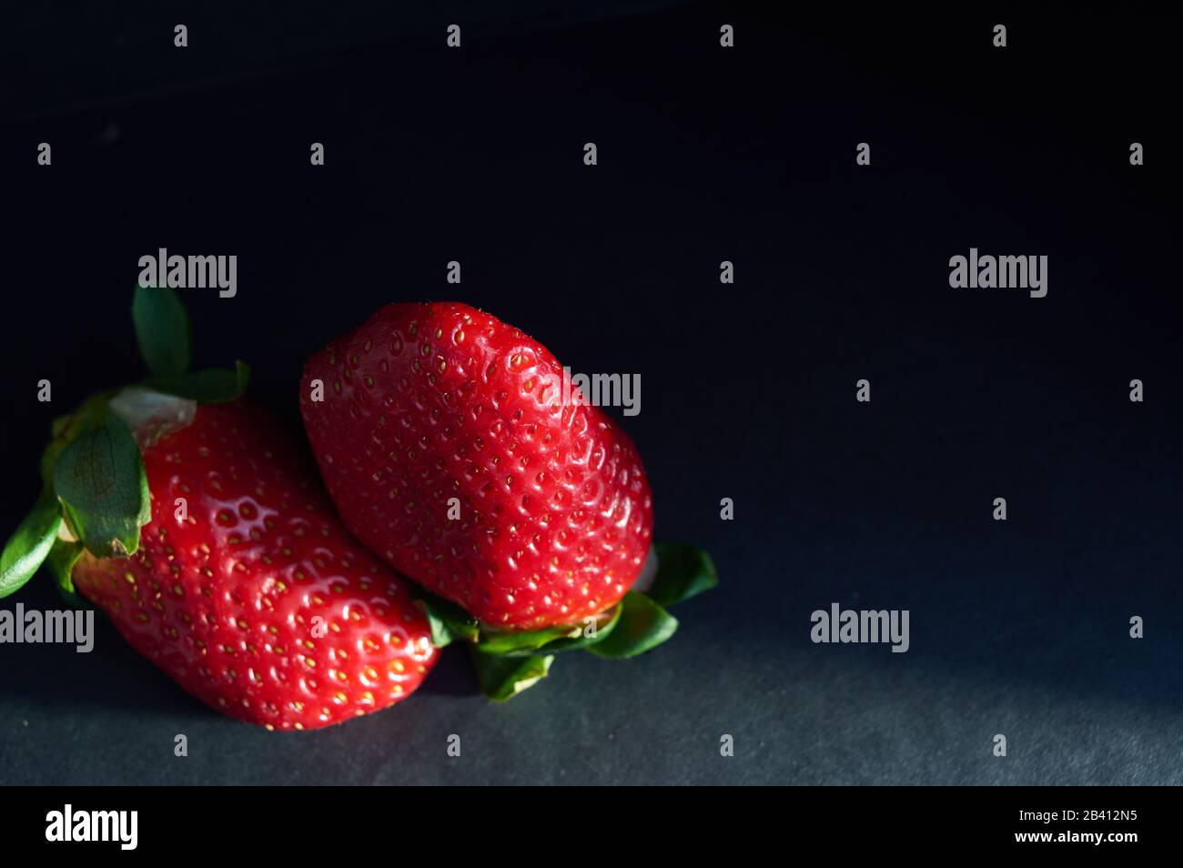 strawberries with natural light and black background Stock Photo - Alamy