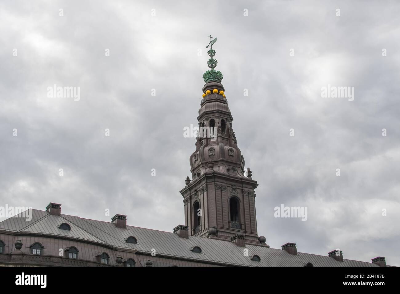 The spire of Christianborg Palace under a gray overcast sky in Copenhagen Denmark. Stock Photo