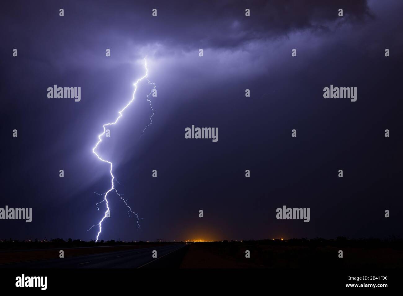 A lightning bolt from a thunderstorm in a dark, stormy night sky over