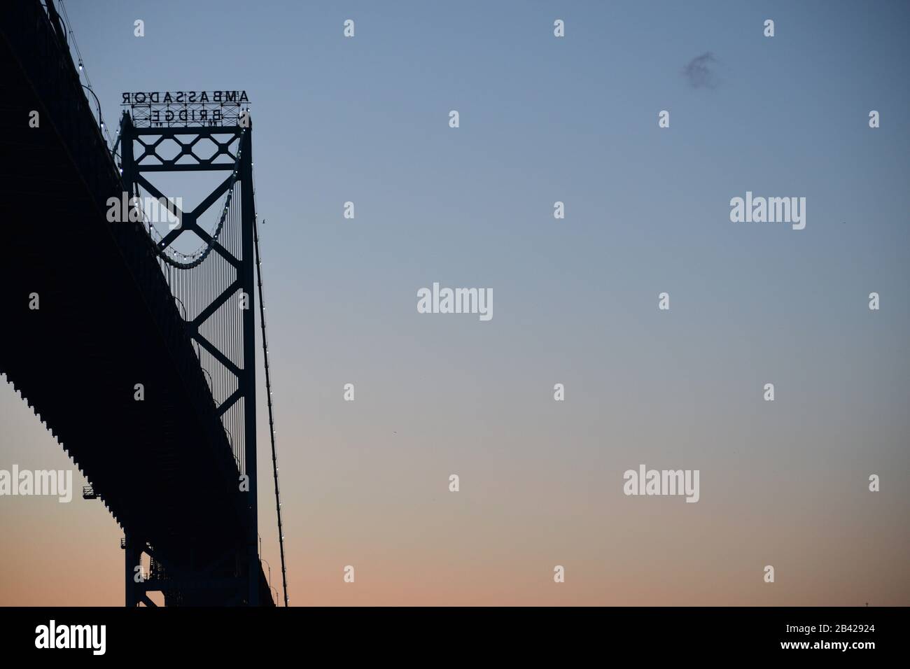 Ambassador bridge view from Windsor, Ontario. Detroit - Canada border crossing at sunset. Space for text in the sky. Stock Photo