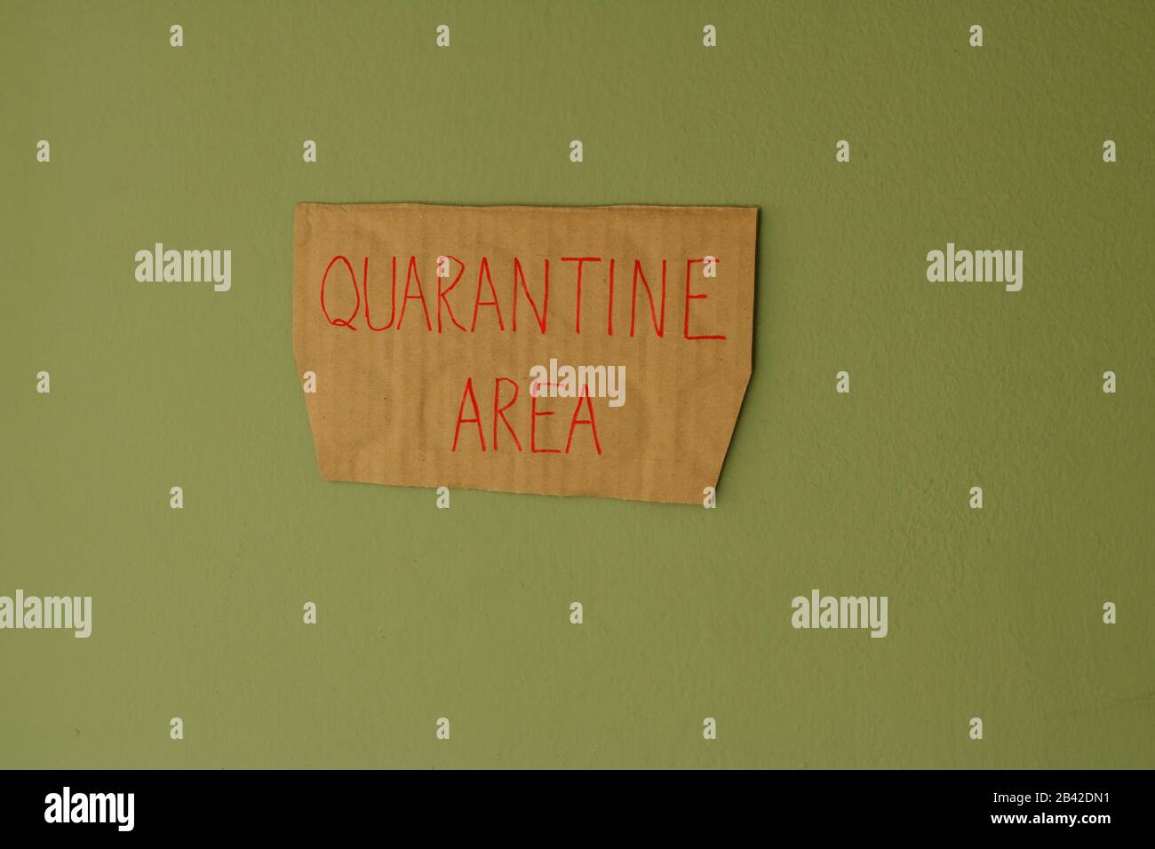Closeup handwriting QUARANTINE AREA cardboard sign attached to the wall, protection and safety concept Stock Photo