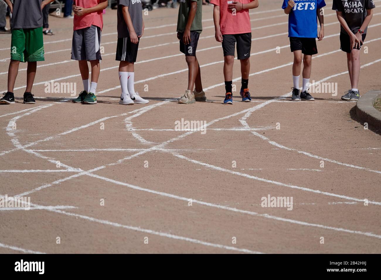 The bottom half of boys lined up for a race at a track meet. Stock Photo