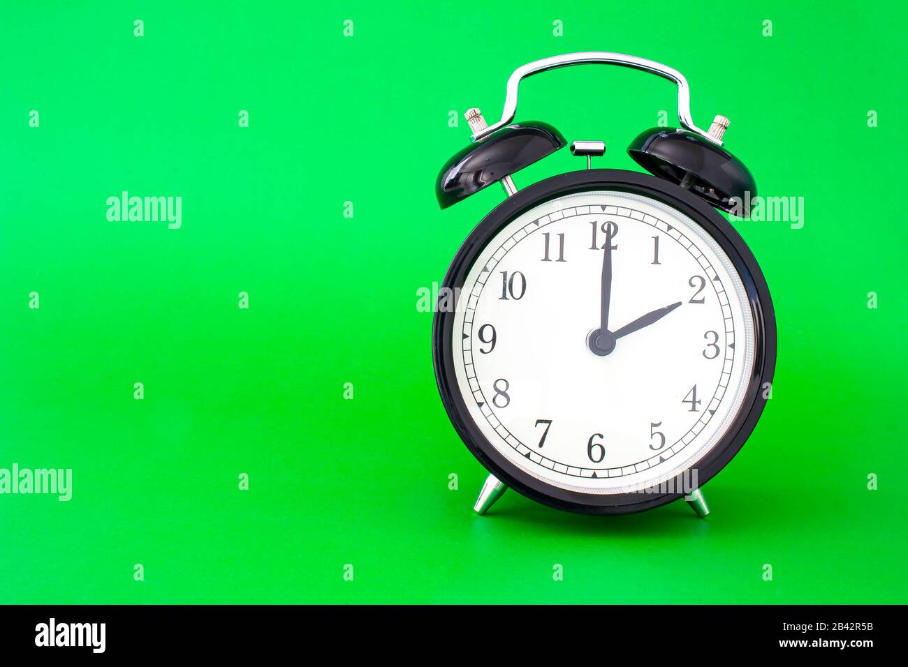 An isolated clock watch on a green background with a soft shadow Stock Photo