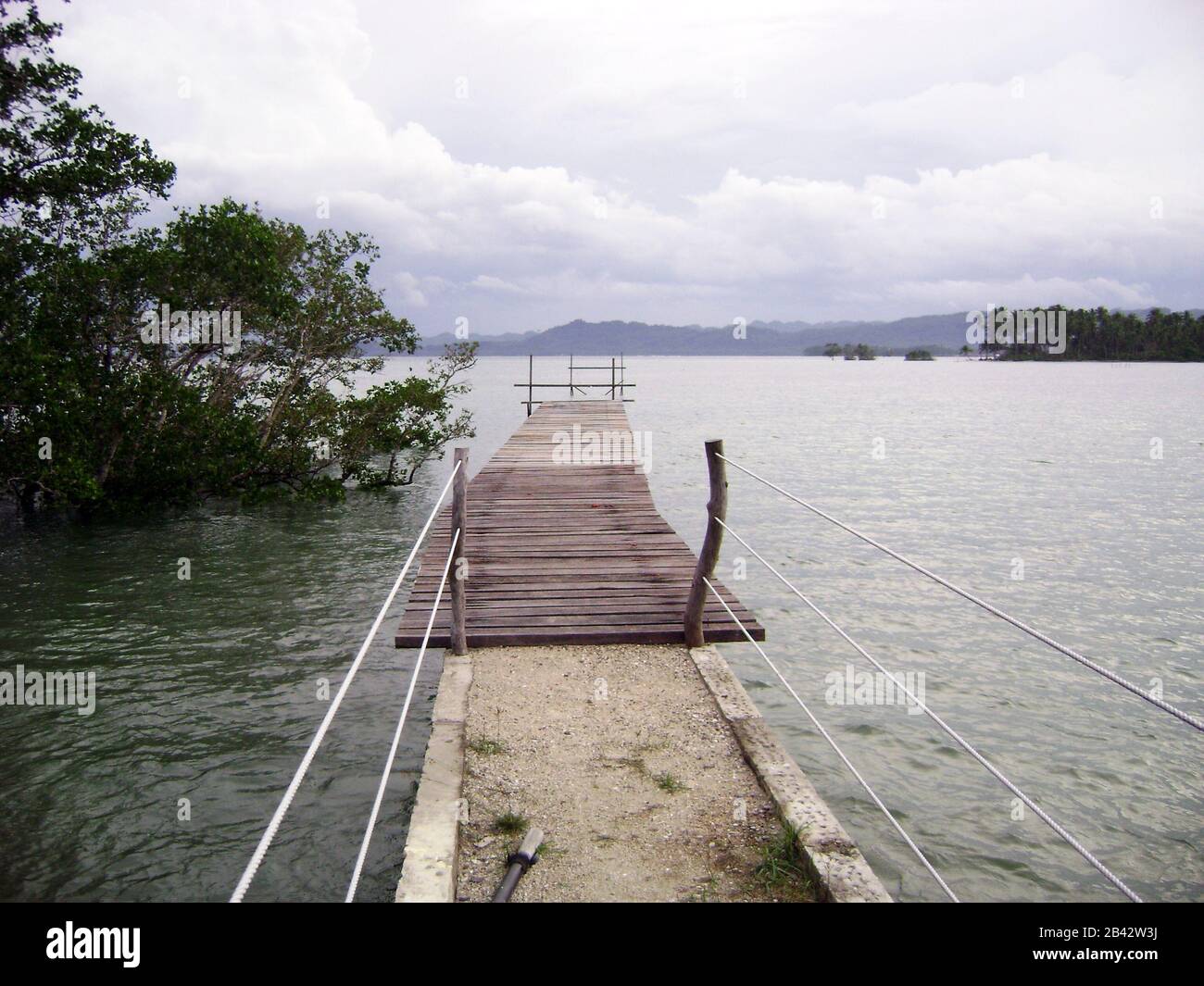 Wooden walkway extending out into the water at a beach in Surigao del Sur, Philippines. Stock Photo
