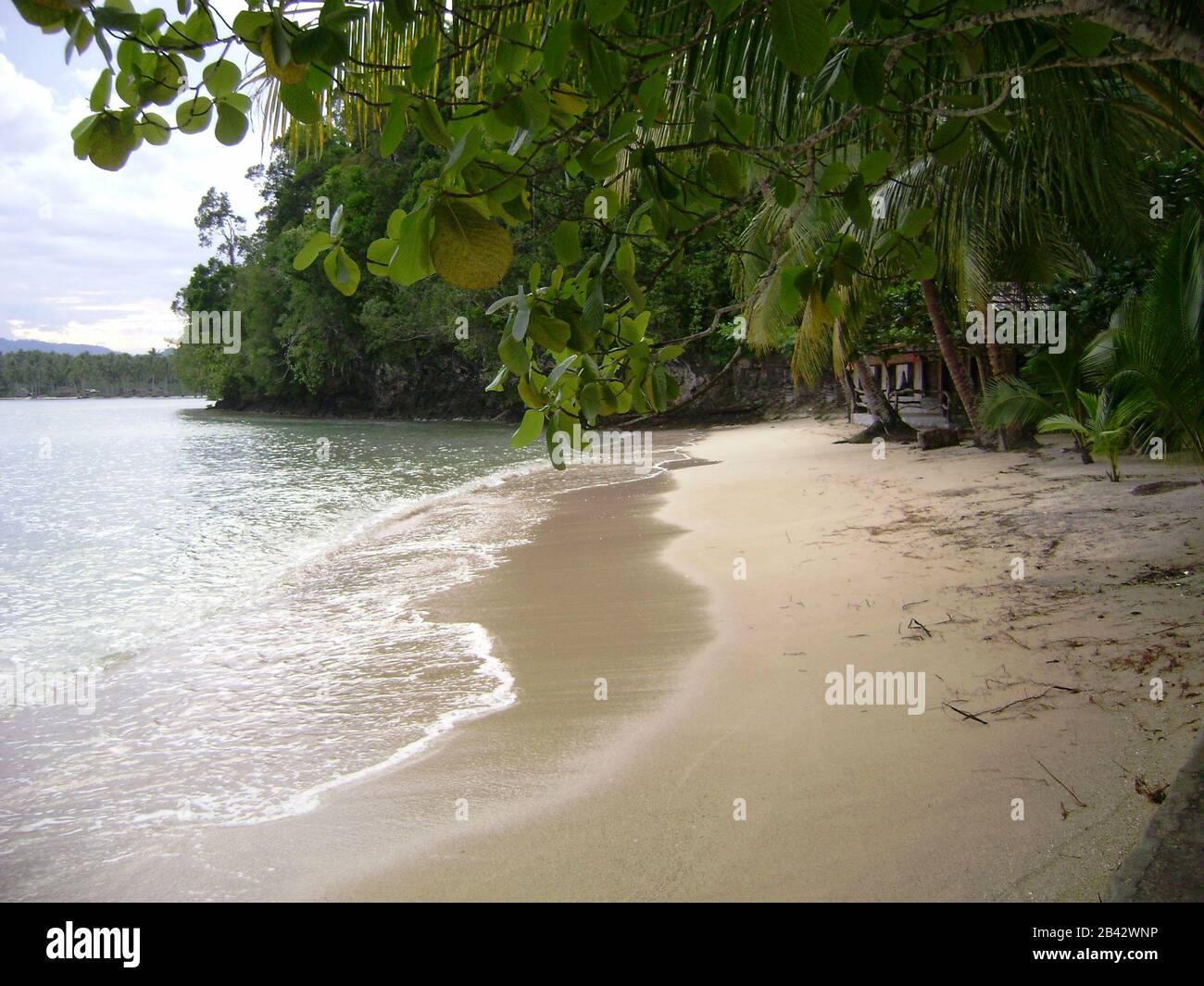 Fine, white sand with soft waves at a resort in Surigao del Sur, Philippines. Stock Photo