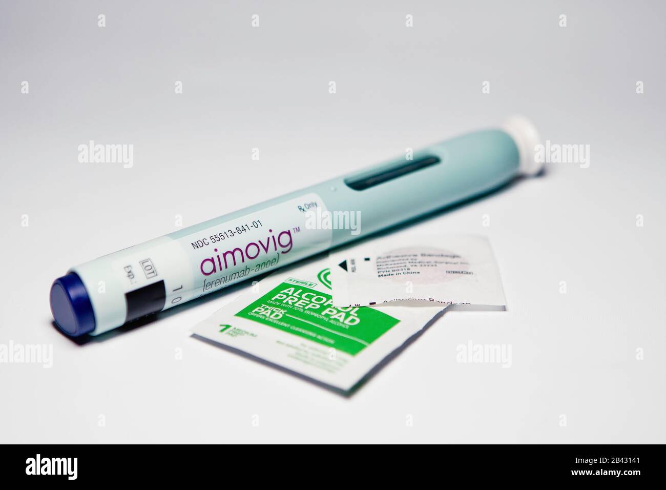 Aimovig (erenumab-aooe) 70 mg auto-injector device, prescription drug migraine prevention, alcohol wipe, spot bandage, studio, color, United States Stock Photo