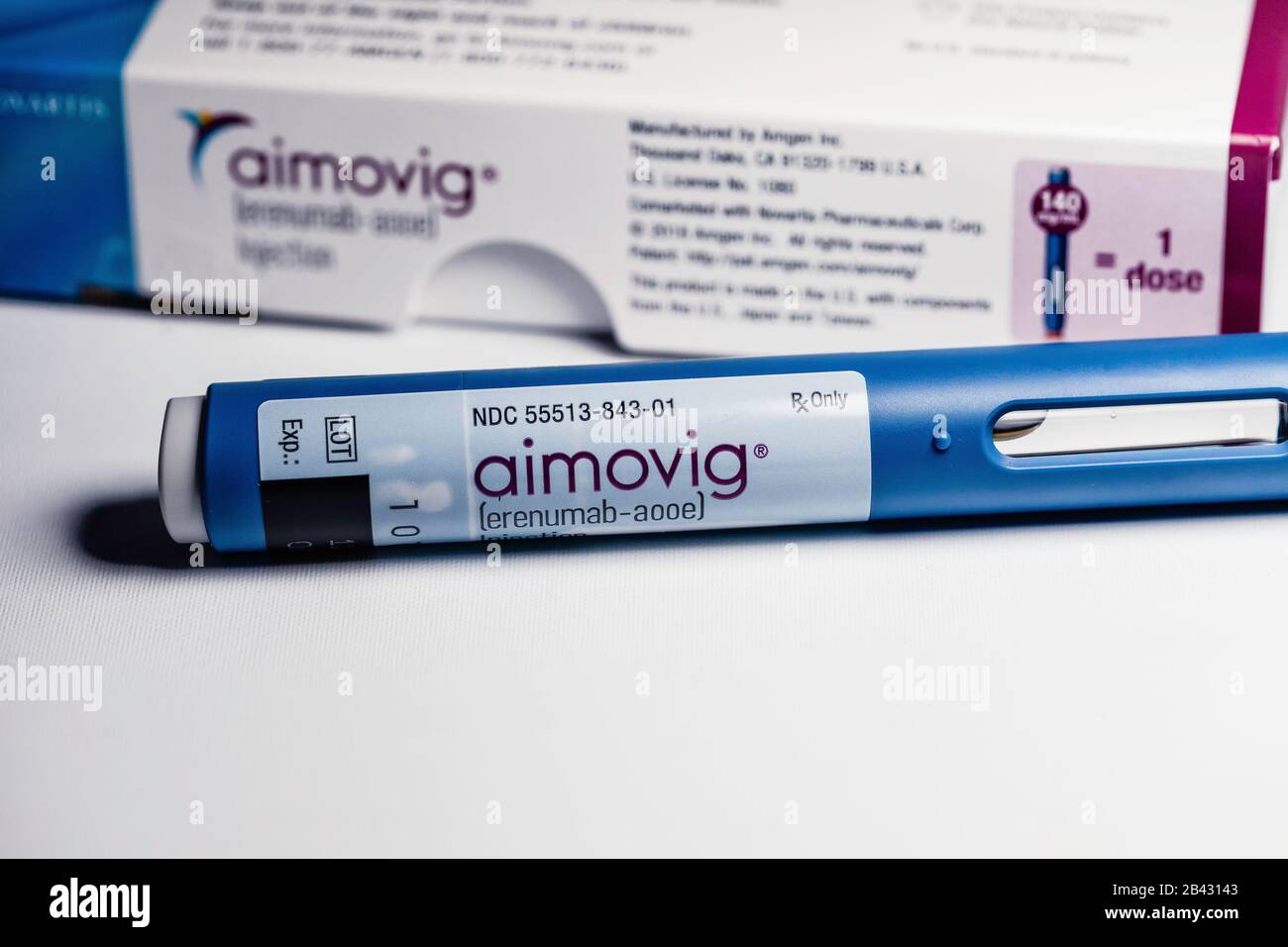 Closeup of Aimovig (erenumab-aooe) 140 mg auto-injector device, prescription drug for migraine prevention, and box, studio, color, United States Stock Photo
