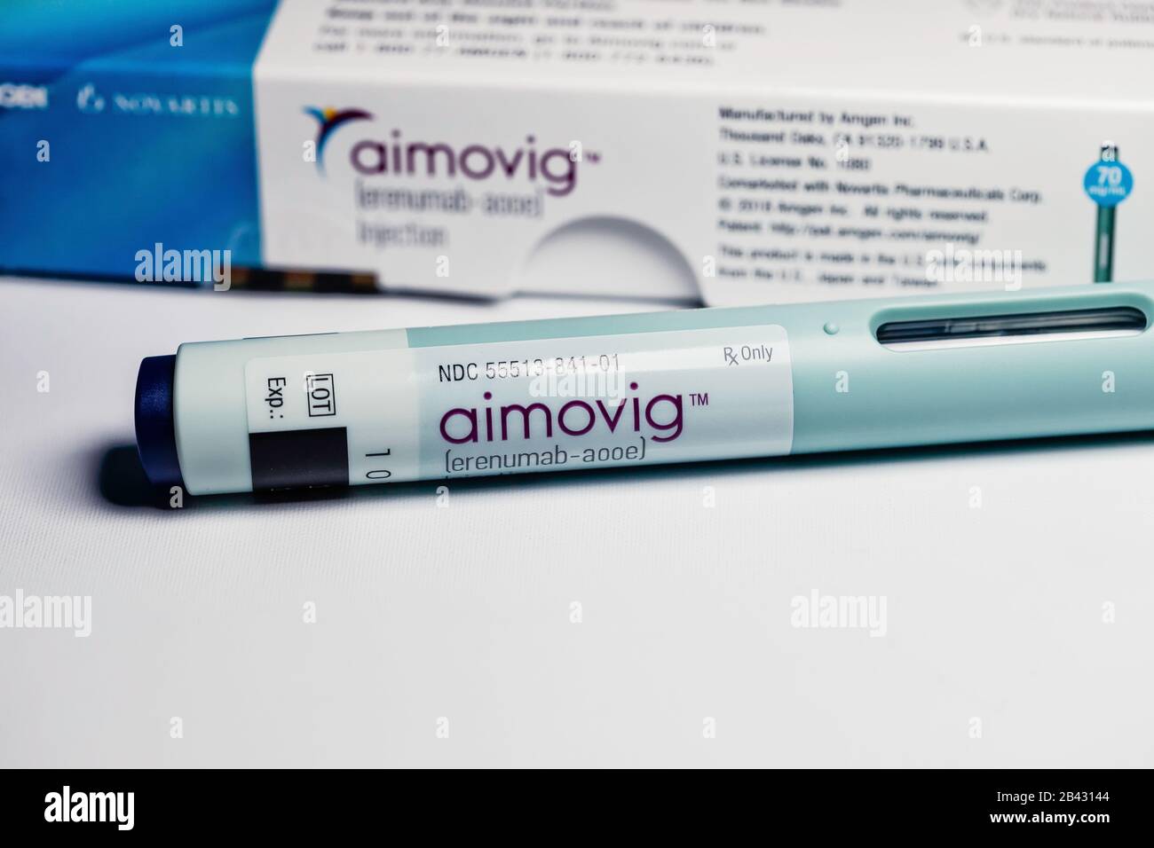 Closeup of Aimovig (erenumab-aooe) 70 mg auto-injector device, prescription drug for migraine prevention, and box, studio, color, United States Stock Photo