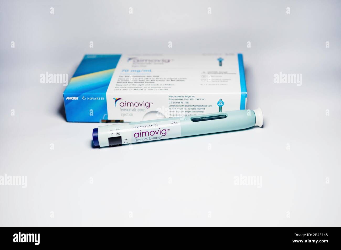Aimovig (erenumab-aooe) 70 mg auto-injector device, prescription drug for migraine prevention, and box, studio, color, United States Stock Photo