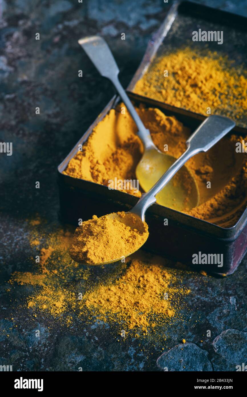 Turmeric powder. Aromatic spice in a tin on a slate background Stock Photo