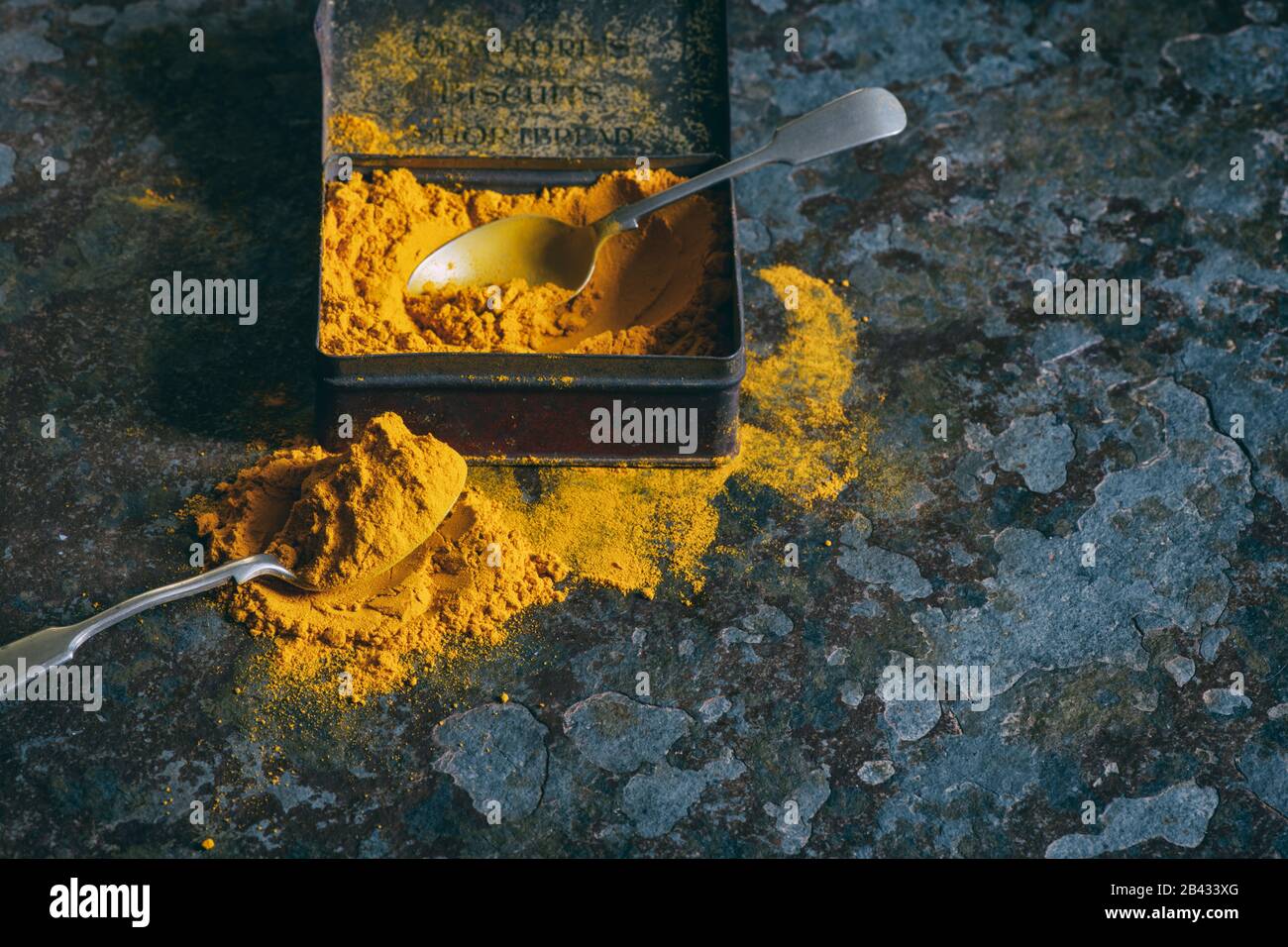 Turmeric powder. Aromatic spice in a tin on a slate background Stock Photo