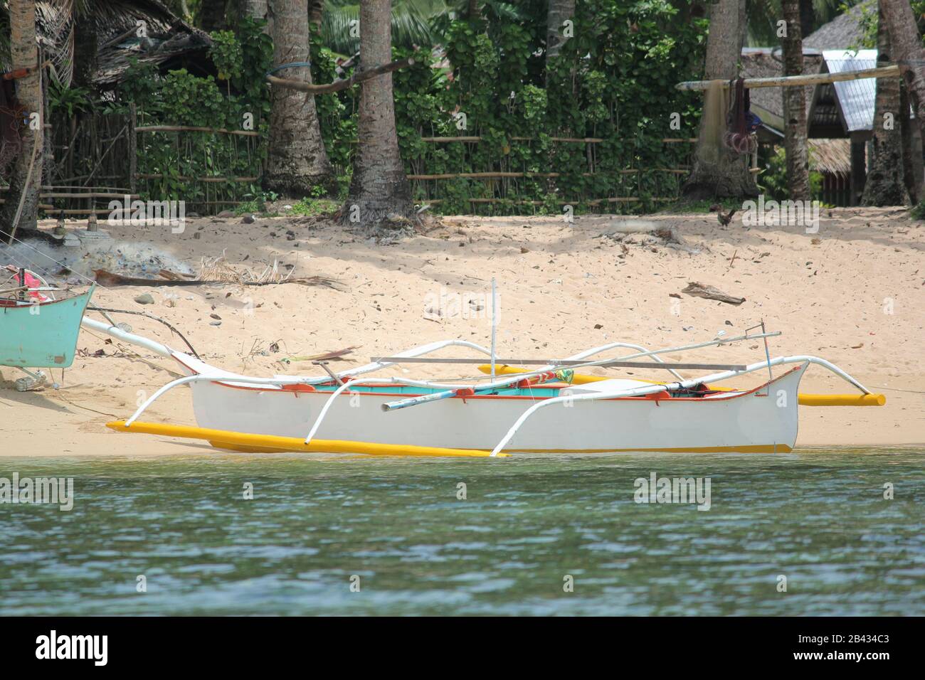 Outrigger boat on the beach of a fishing village, Surigao del Sur, Philippines. Stock Photo