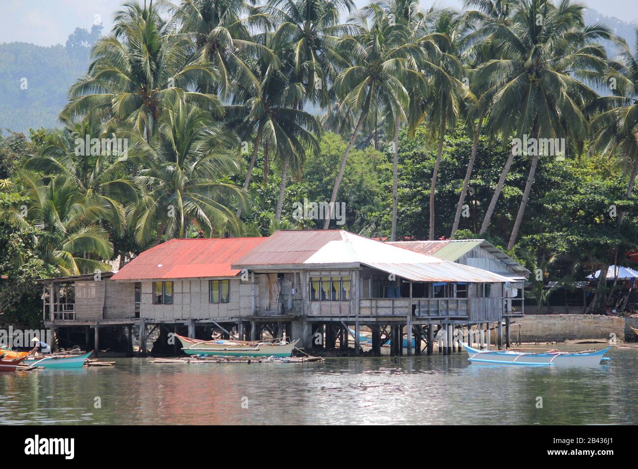 Outrigger boats and houses on stilts in a fishing village in Surigao del Sur, Philippines. Stock Photo