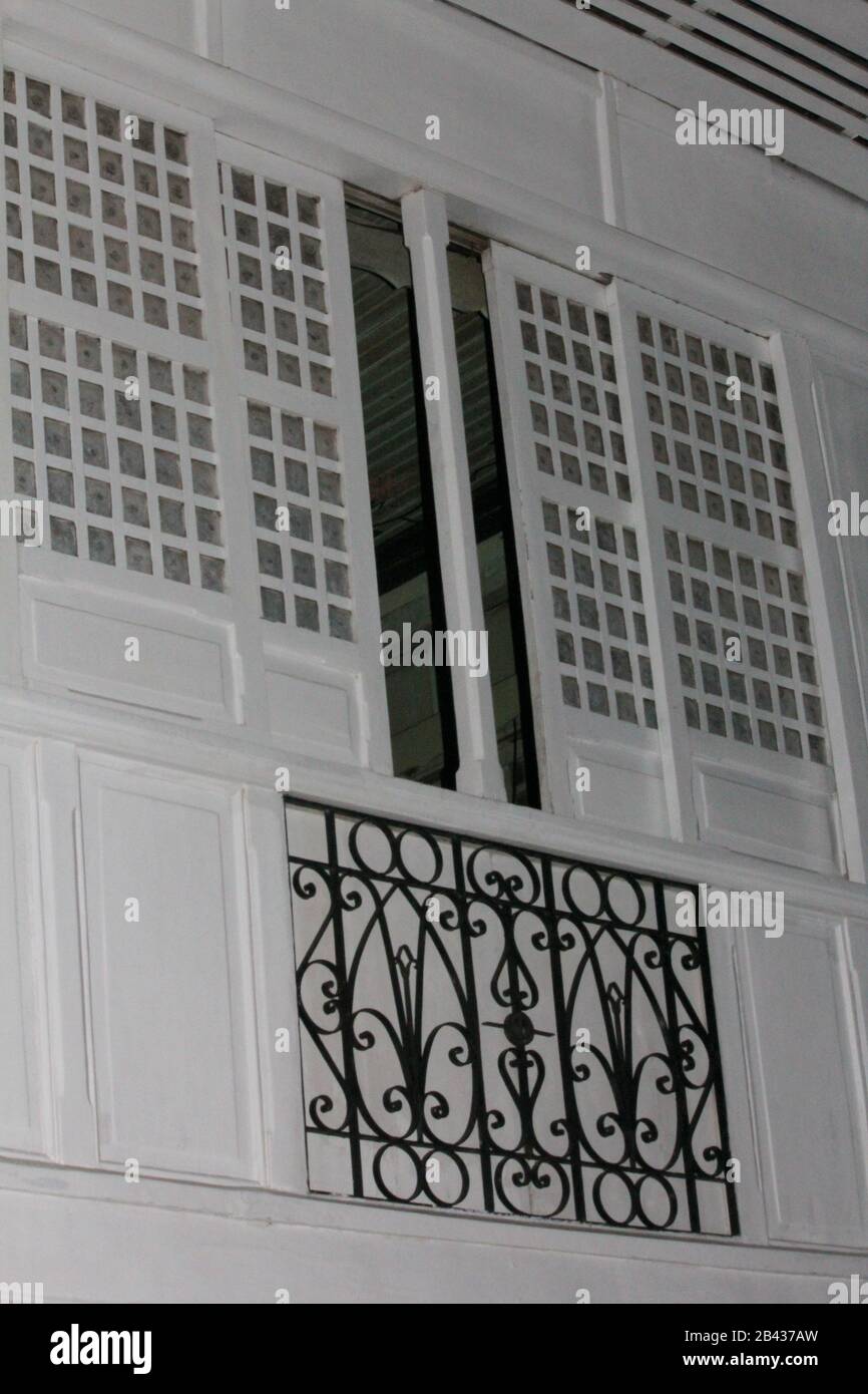 Old fashioned  window and wrought iron decor from outside a century-old mansion. Stock Photo