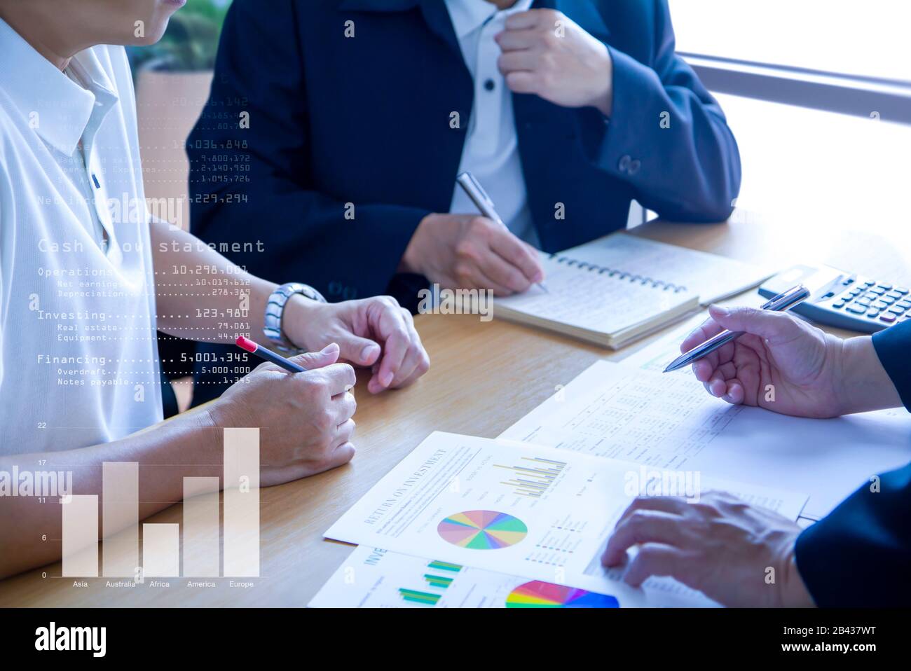 Business men in a meeting discuss and review financeial statements and reports on business performance and return on investment, ROI. Stock Photo