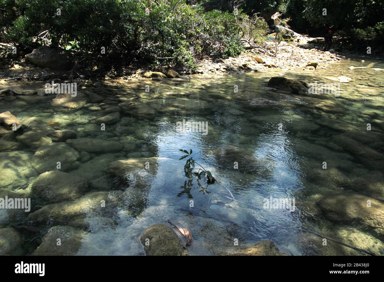 Riverside scene with stones visible through crystal clear waters. Stock Photo