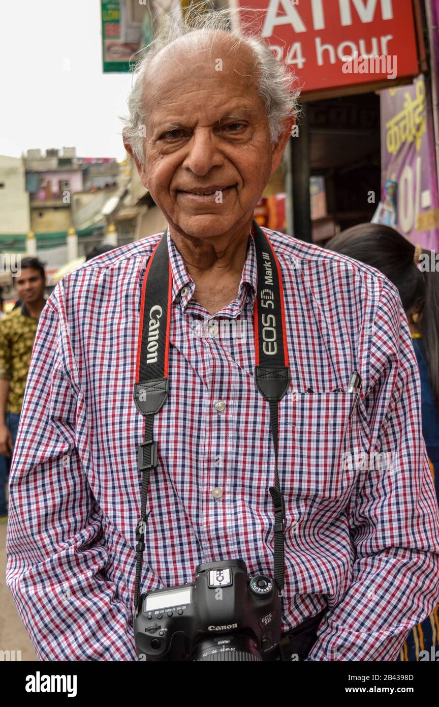 A old age photographer poses for camera at chandani chowk market. Stock Photo