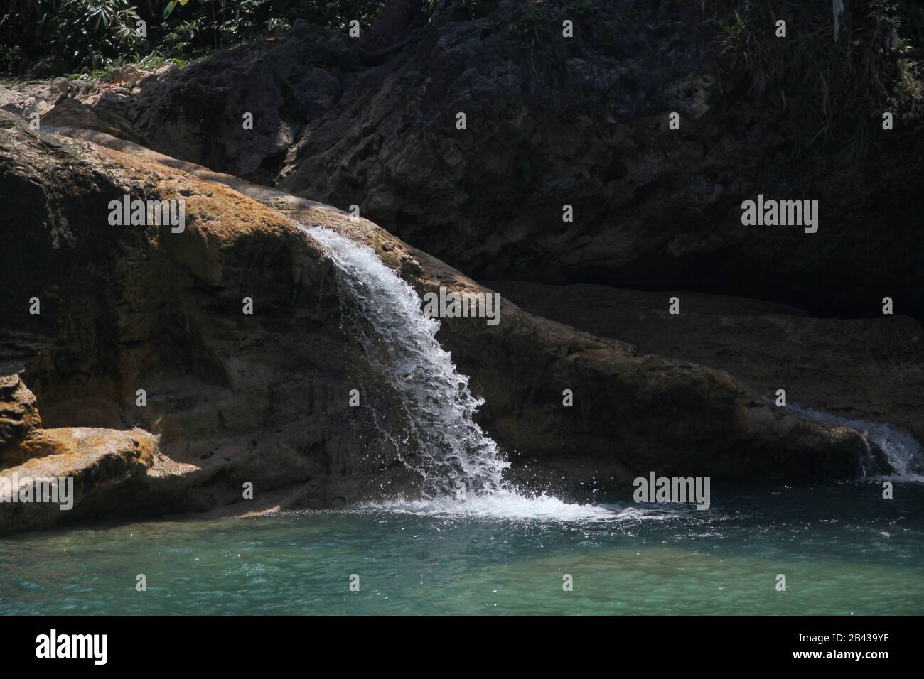 Crystal clear water cascades down Baobao Falls, one of the attractions in Liangga, Surigao del Sur, Philippines. Stock Photo