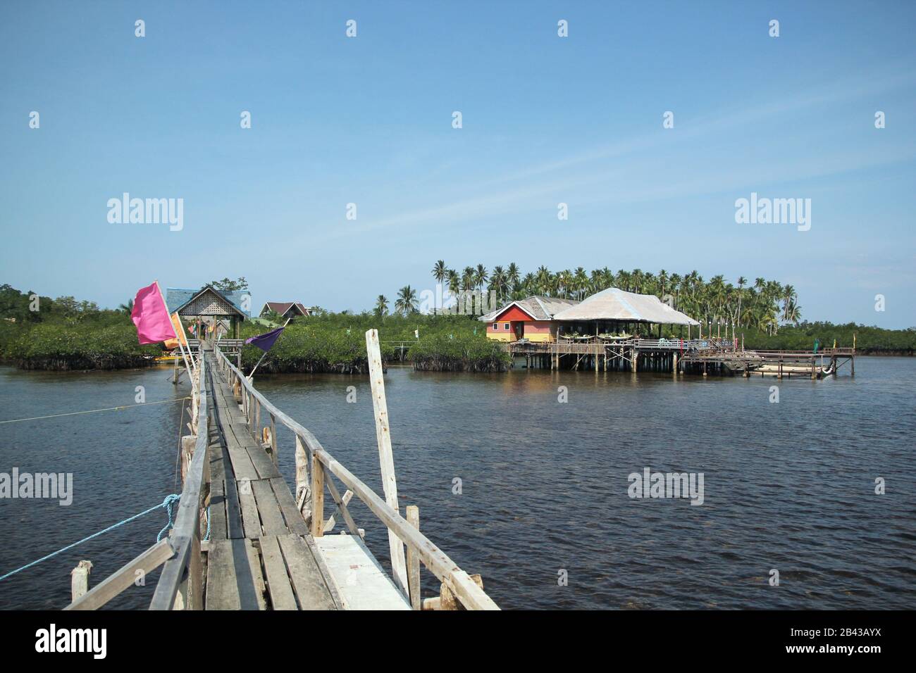 Wooden walkway with wooden cottages on stilts at Surigao del Sur, Philippines. Stock Photo