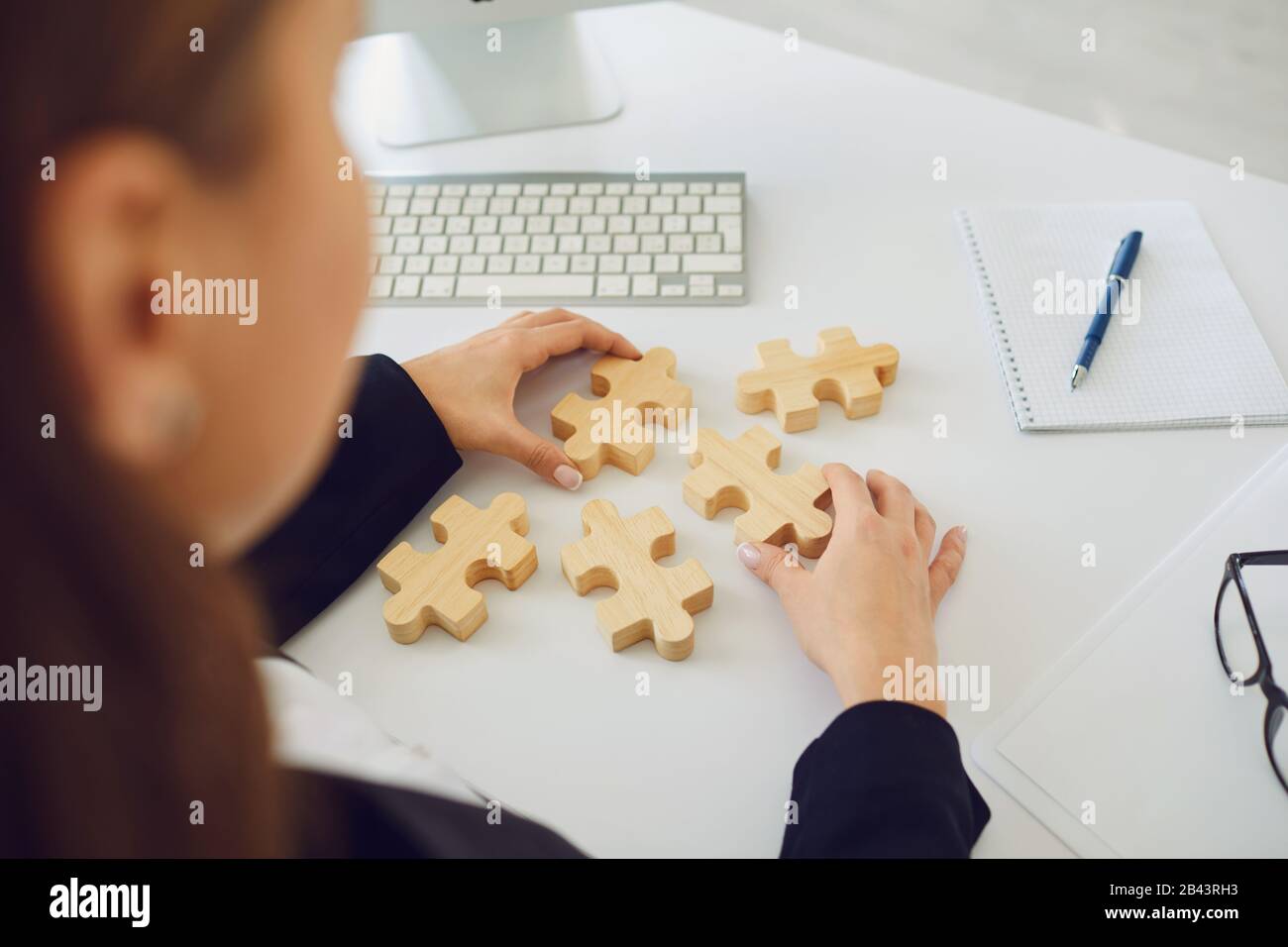 Faceless Hands Of A Businesswoman With Wooden Puzzles On A White