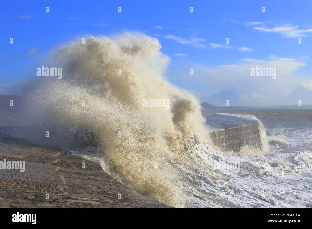 Big wave splashing on The Cobb during high tide and strong wind Stock Photo