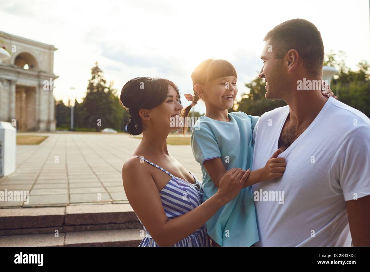 Happy smiling family hugging on the street. Stock Photo