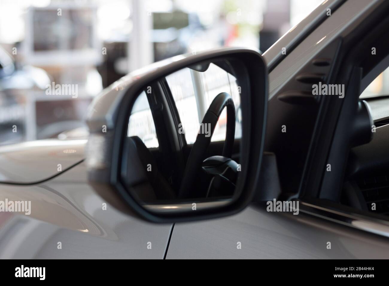Reflection in side mirror of the car steering wheel. Modern