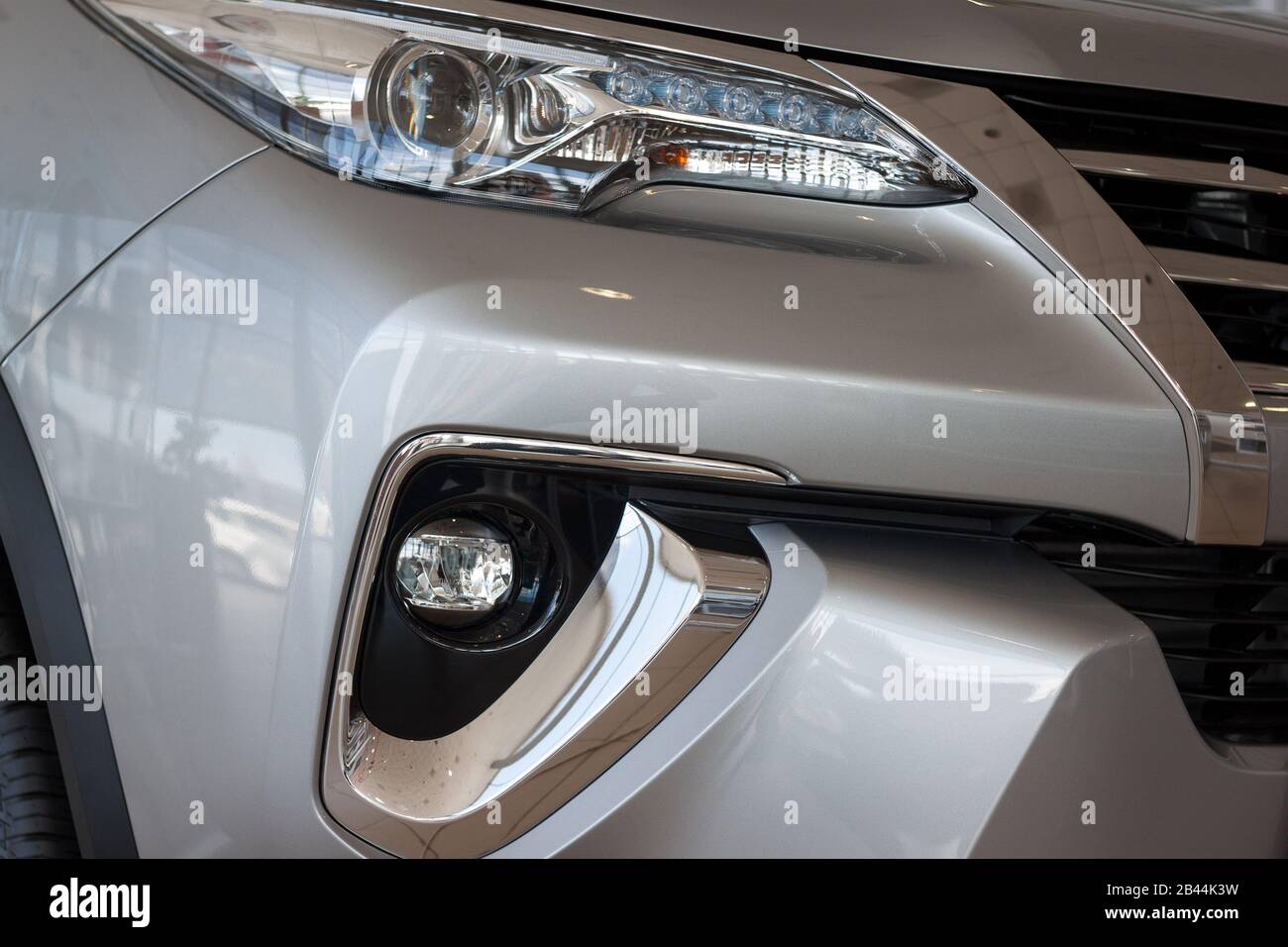 New vehicle with elegant head lamps in showroom. Side view. Stock Photo