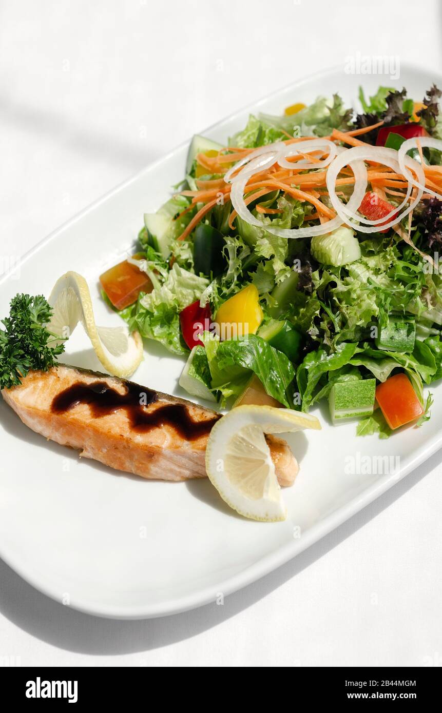 organic mixed vegetable salad with salmon fillet and balsamic