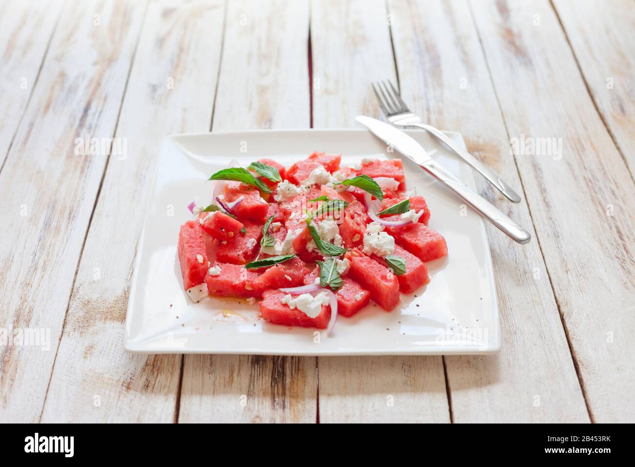 Fresh watermelon salad with feta cheese and mint on a white plate Stock Photo