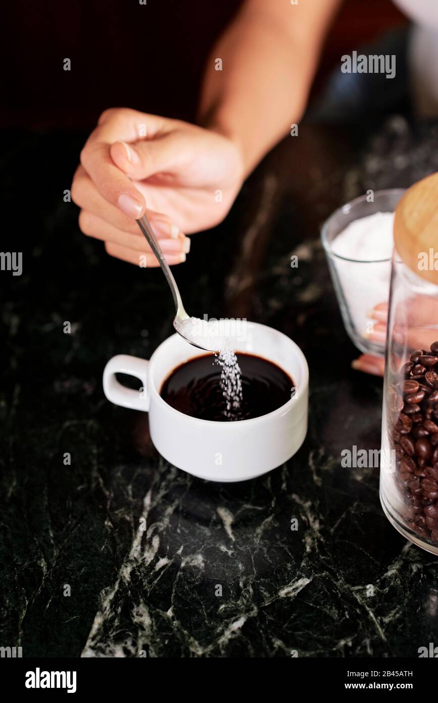 Woman adding spoon sugar hi-res stock photography and images - Alamy