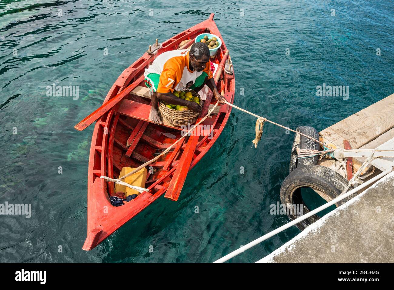 Wallilabou Bay, Saint Vincent and the Grenadines - December 19, 2018: Fruit merchant in a wooden boat brought fruit to the Wallilabou Anchorage - Pira Stock Photo