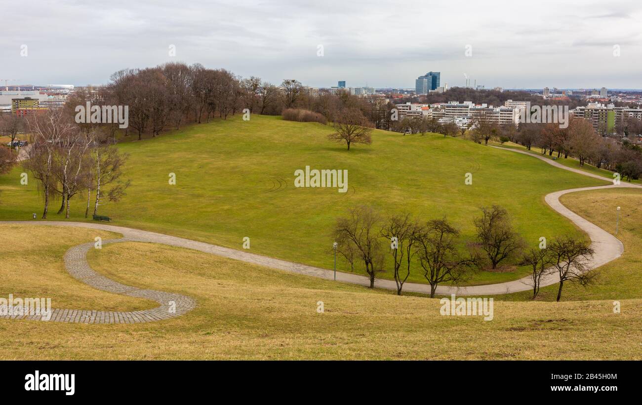 View of the Olympic Park (Olympiapark) with gentle, green hills and winding path which runs through the meadow. Popular with locals and tourists. Stock Photo