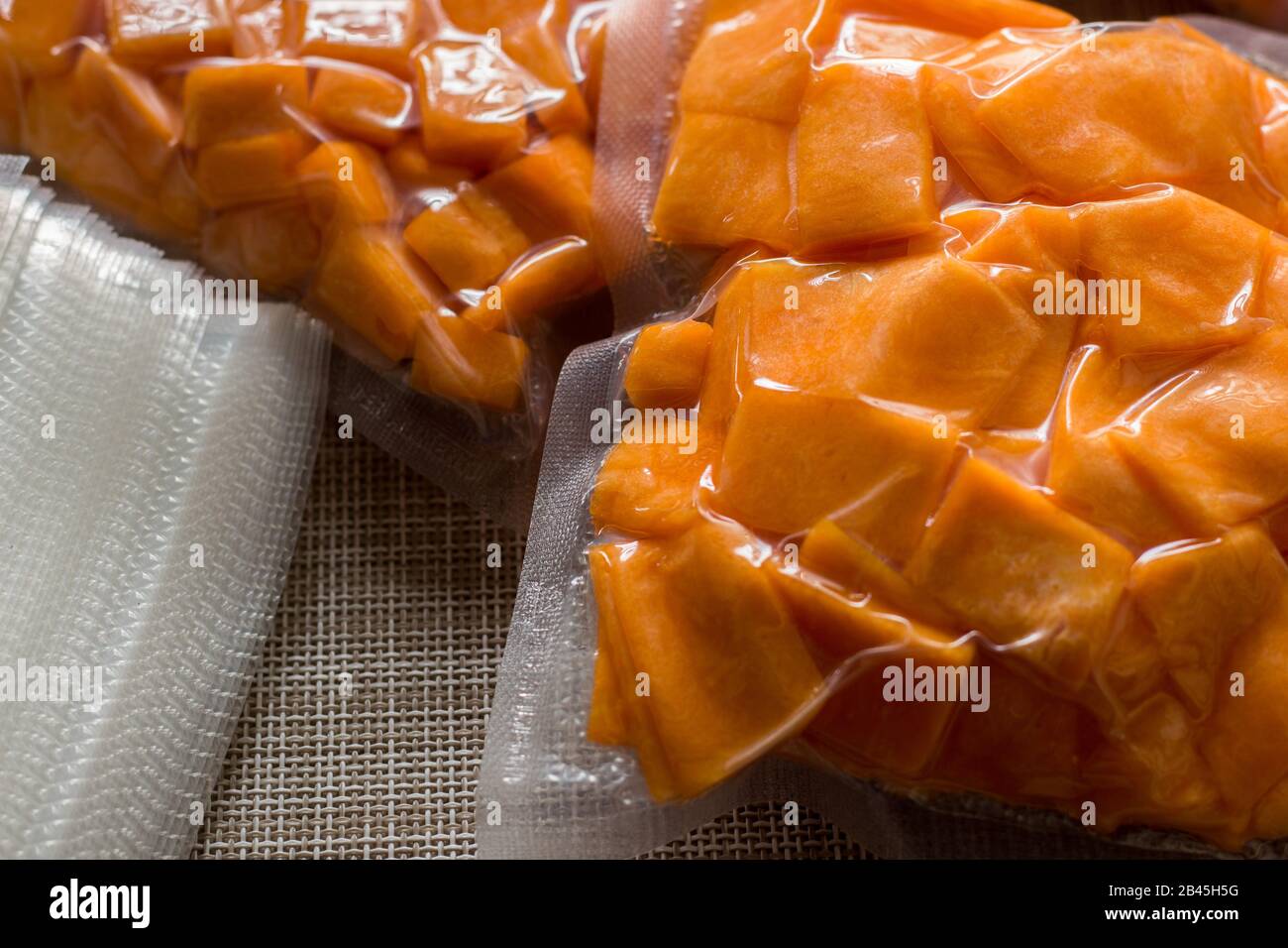 yellow pumpkin cut into slices and cubes and vacuum packed Stock Photo