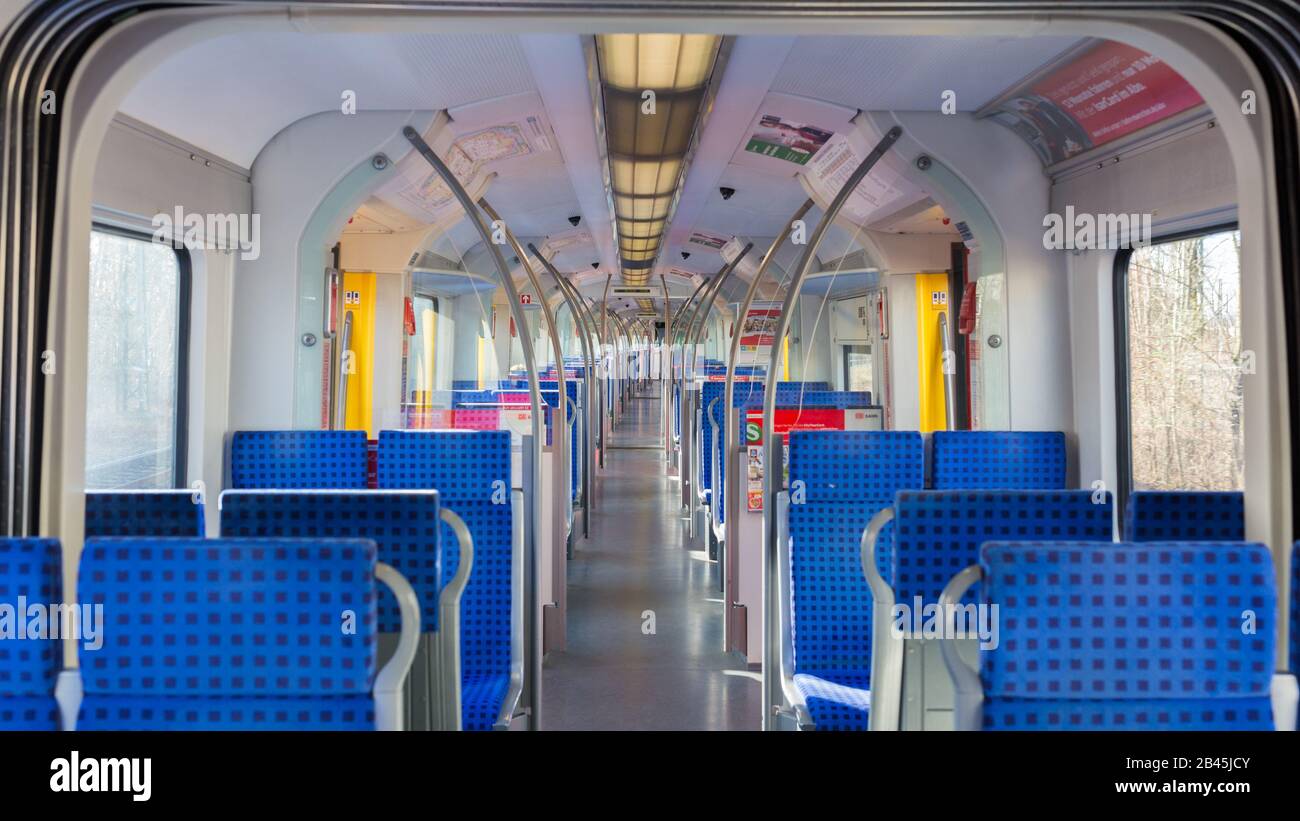 Interior of an empty S-Bahn of MVG / MVV (public transport train). Straight view along the main aisle of an empty compartment. Blue seats, Panorama. Stock Photo