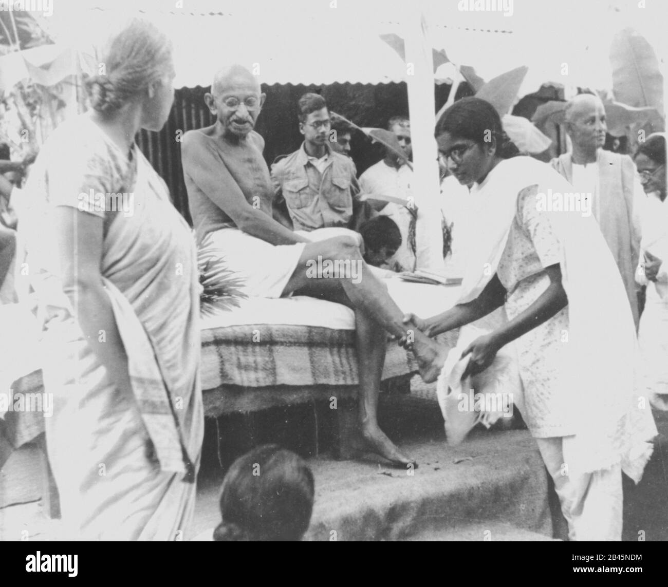 Mahatma Gandhi feet being washed by grand daughter Manu after the end of the daily march in Noakhali West Bengal India February 1947 old vintage 1900s picture Stock Photo