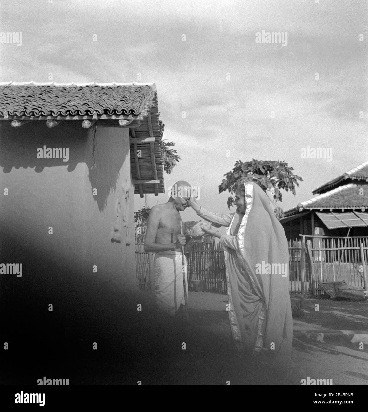 Mahatma Gandhi welcome by Parsi woman in front of hut, Sevagram Ashram, Wardha, Maharashtra, India, Asia, January 1942, old vintage 1900s picture Stock Photo