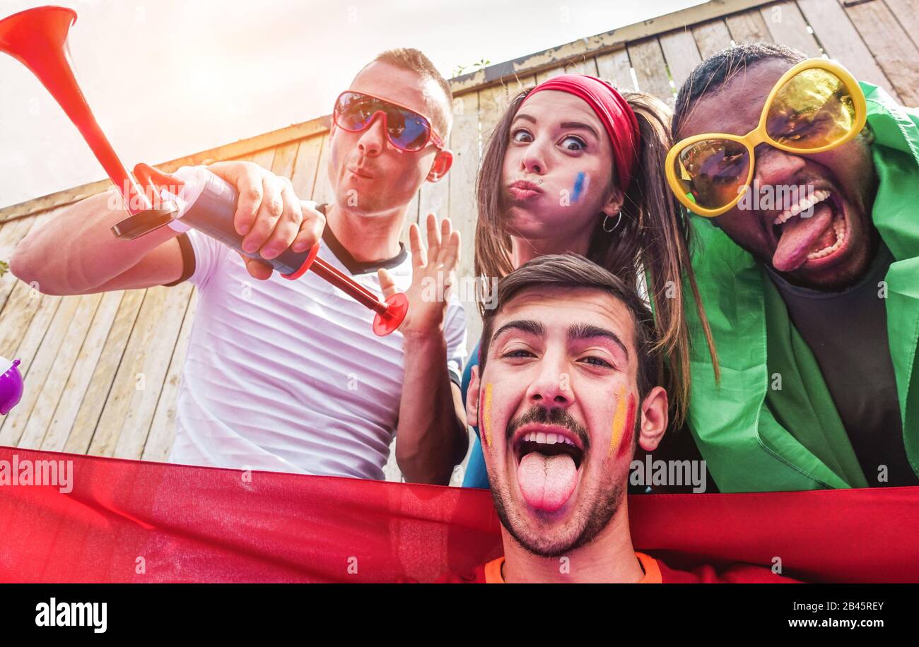 Happy sport supporters having fun during football world game Young