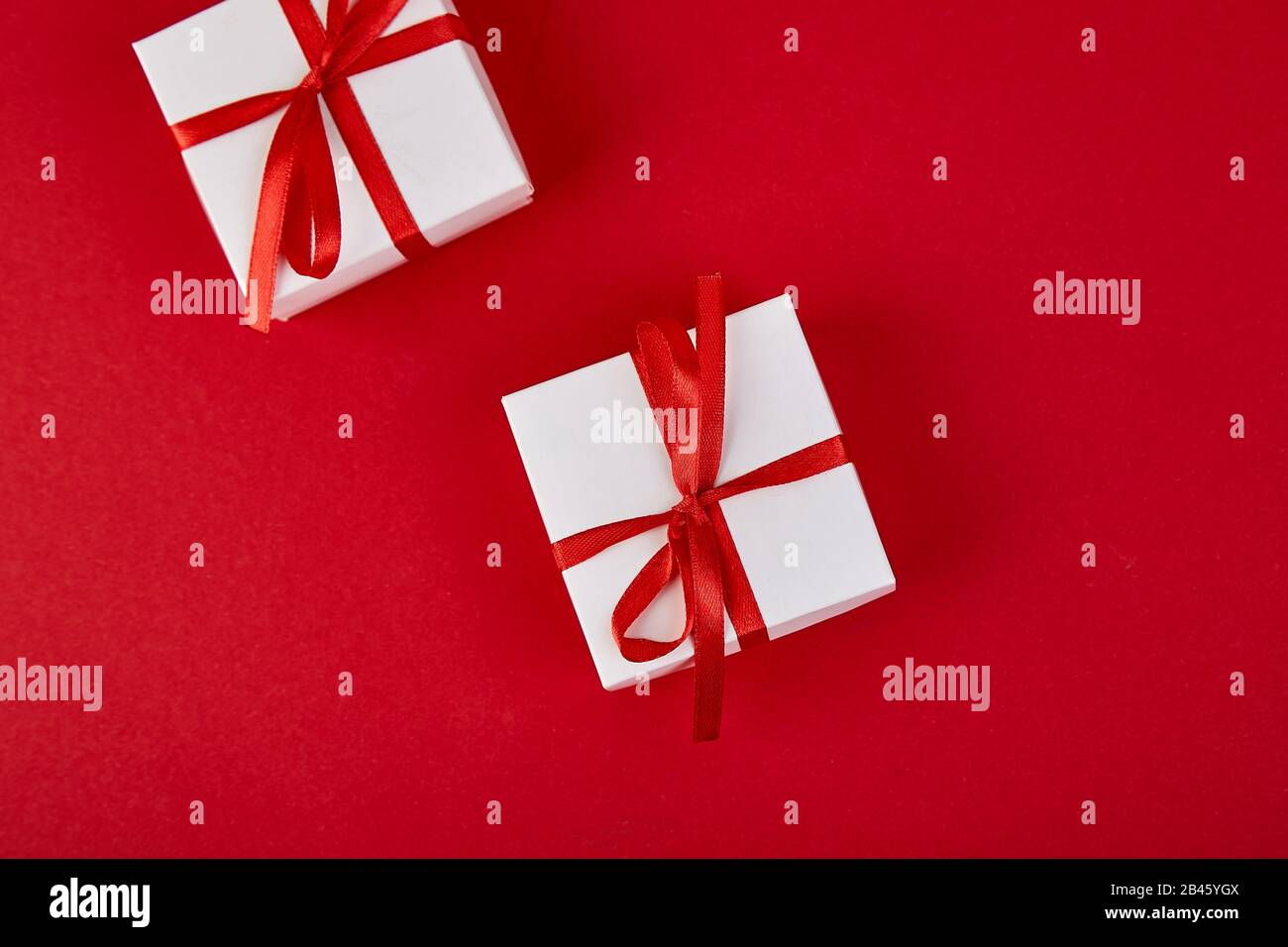 Luxury white gift boxes with red ribbon on red background. Valentine ...