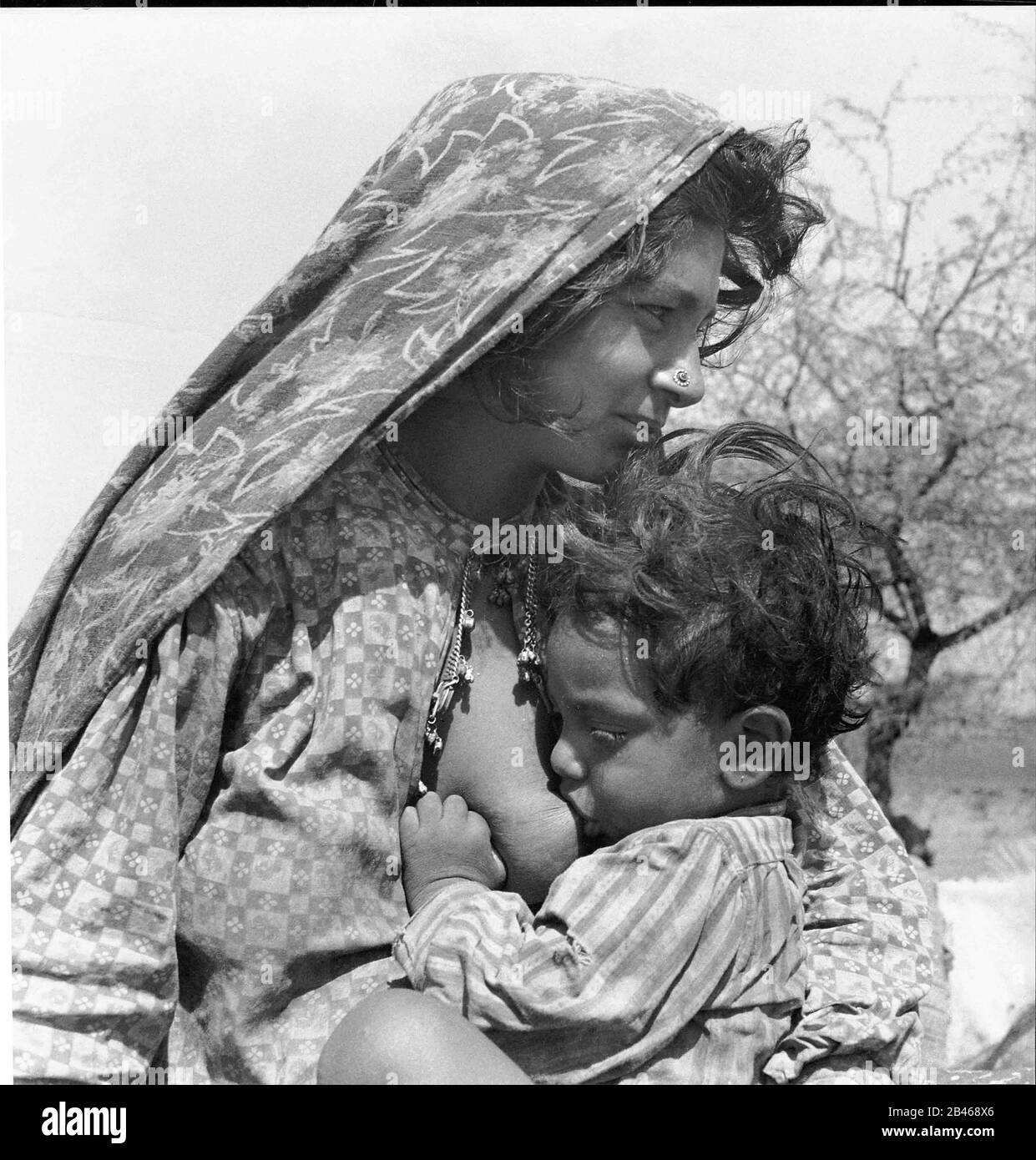 Breastfeeding, baby suckling, Makara Tribe, Veraval, Gir Somnath district, Saurashtra, Gujarat, 1963, old vintage 1900s picture Stock Photo