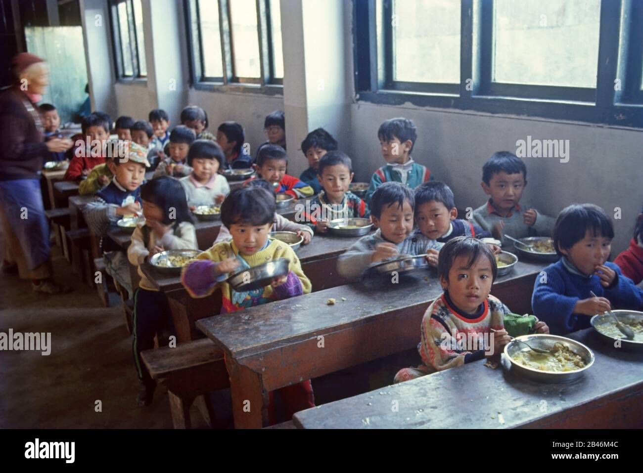 Tibetan child eating lunch in refugee centre Stock Photo