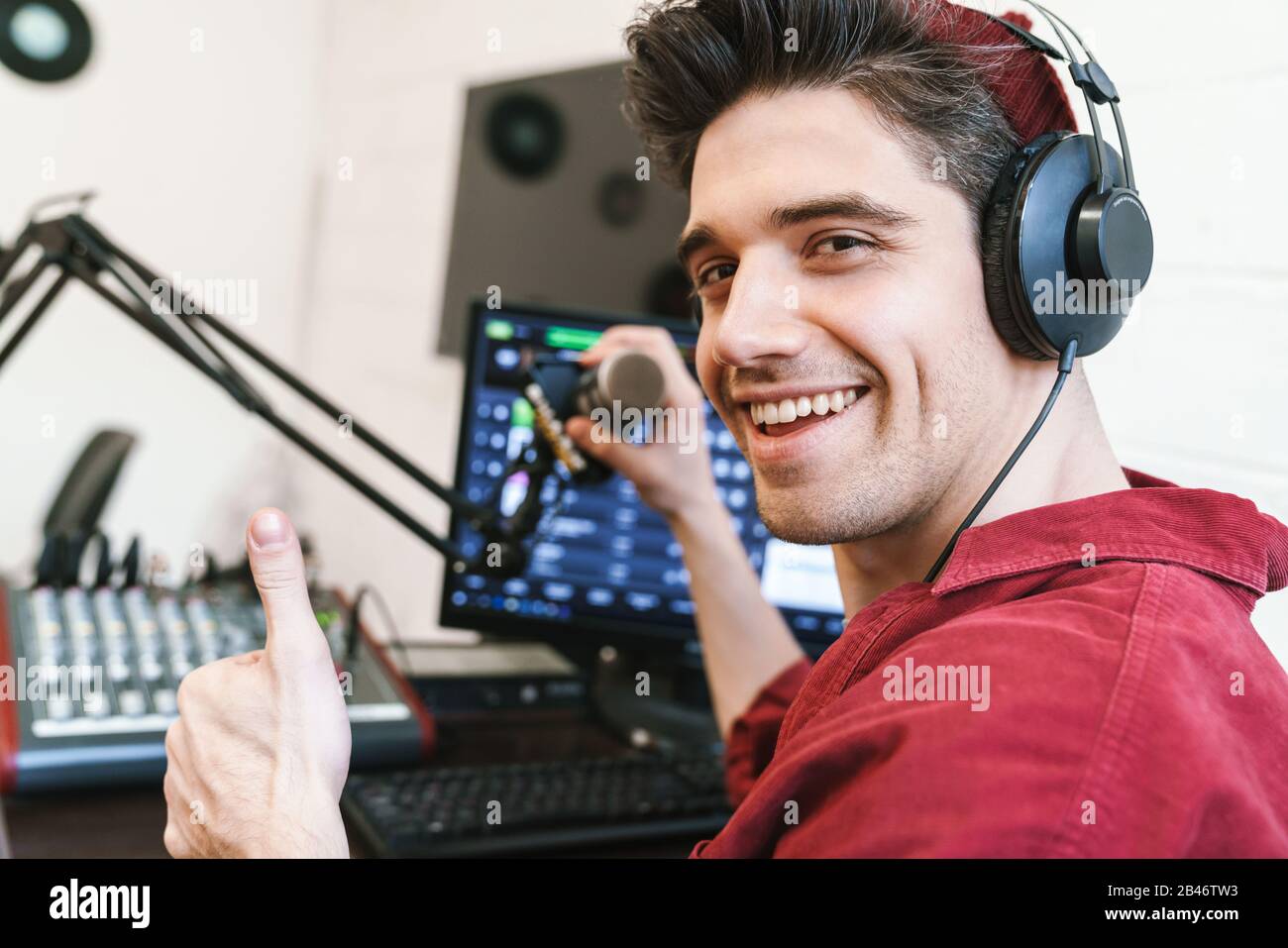 Image of young happy caucasian dj man wearing headphones working at radio  station while making podcast recording for online show Stock Photo - Alamy