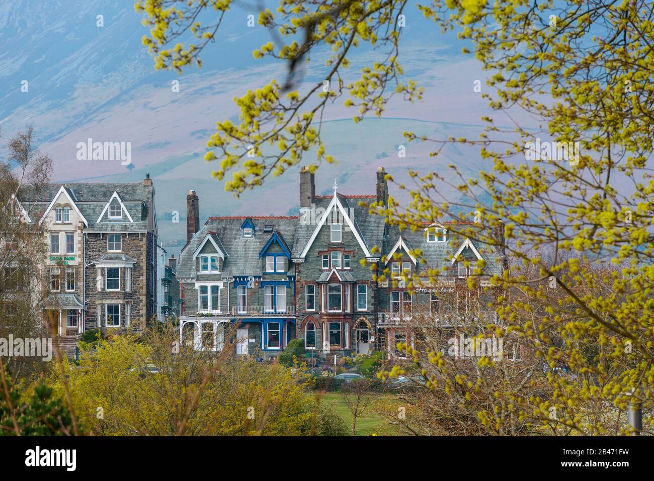 A row of Victorian houses (hotels) overlooking Crow Park on the northern shore of Derwentwater in Keswick, Lake District, UK, with the Skiddaw behind. Stock Photo